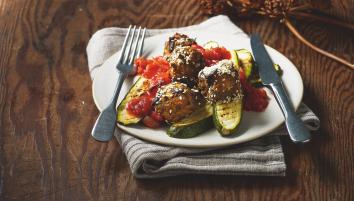 A plate of aubergine meatballs and tomato sauce with courgettes