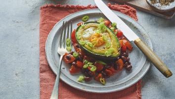 Eggs and avocado on plate with knife and fork